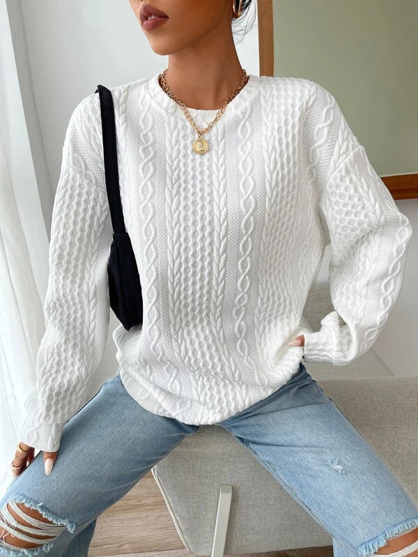 Woman wearing white cable-knit oversized sweater with jeans, front view