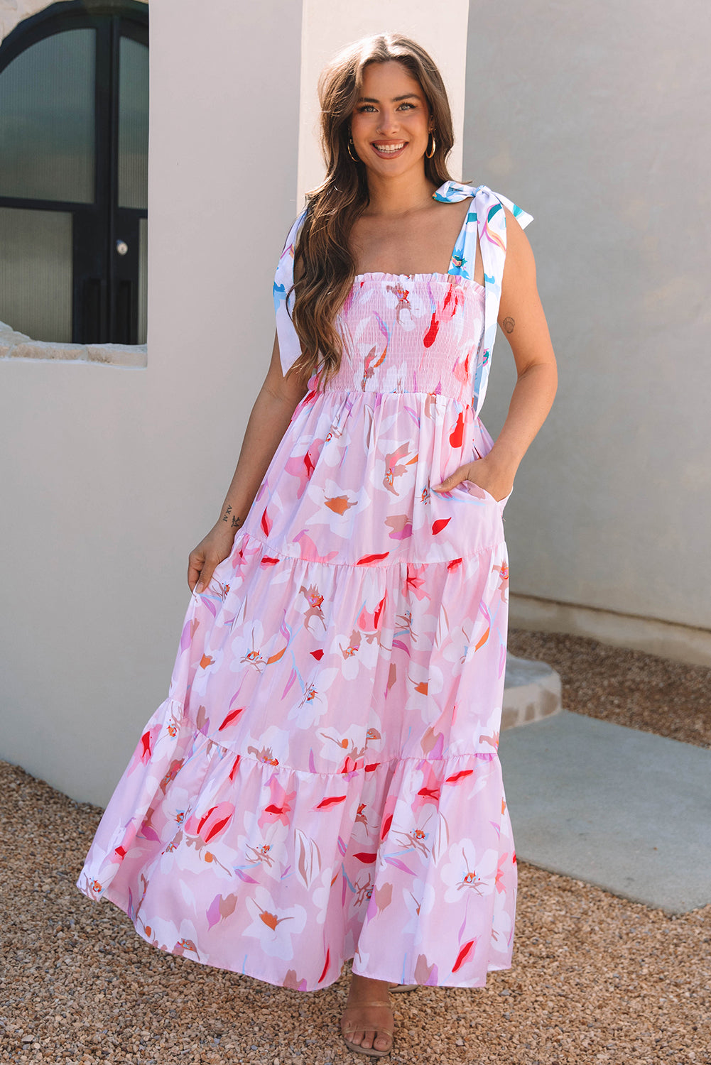 Pink floral sleeveless maxi dress with a flowy tiered skirt shown in motion for an elegant, effortless look