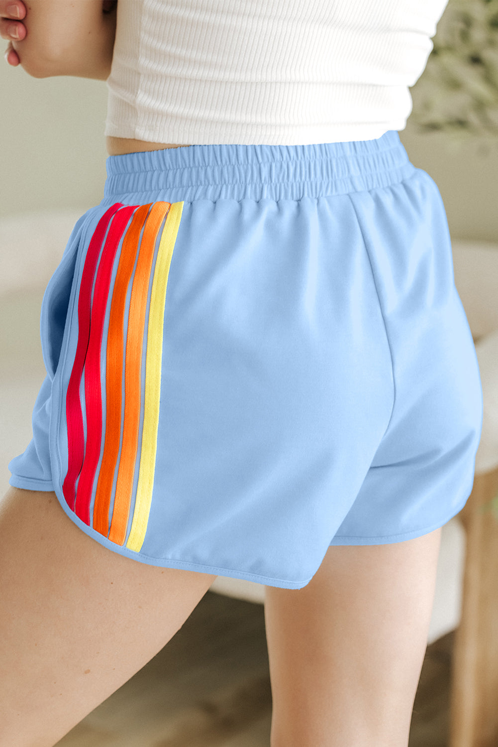Back of women's blue high-waisted shorts with an elastic waistband and lightweight activewear fabric.