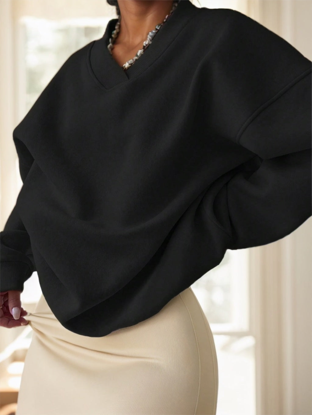 Side view of black oversized drop-shoulder sweatshirt showing relaxed fit