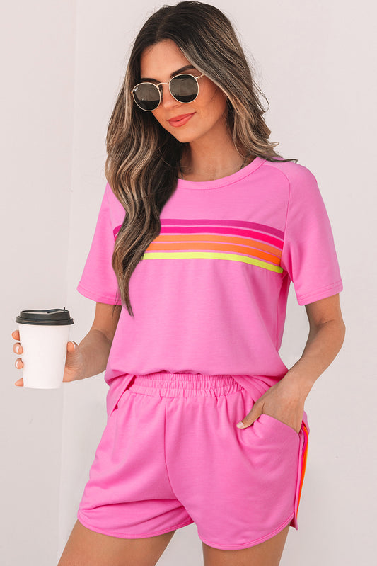 Woman wearing a pink striped short sleeve T-shirt with a relaxed fit and colorful horizontal stripe detail.
