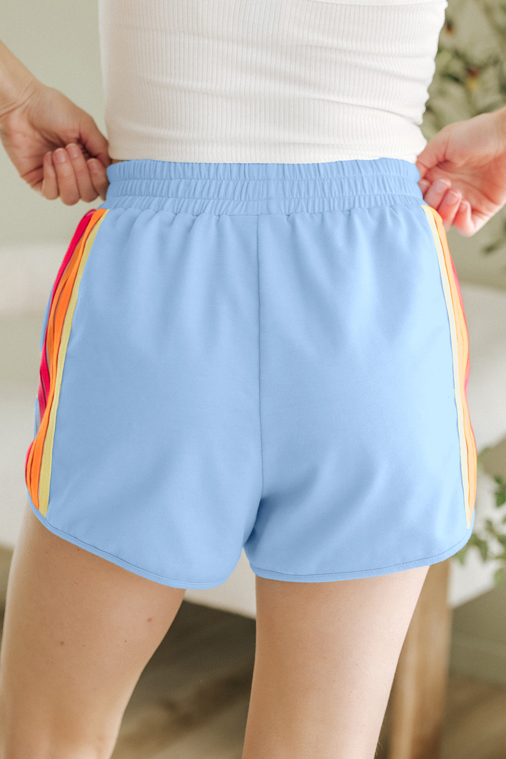 Close-up of the colorful color block side stripe design on blue high-waisted workout shorts.