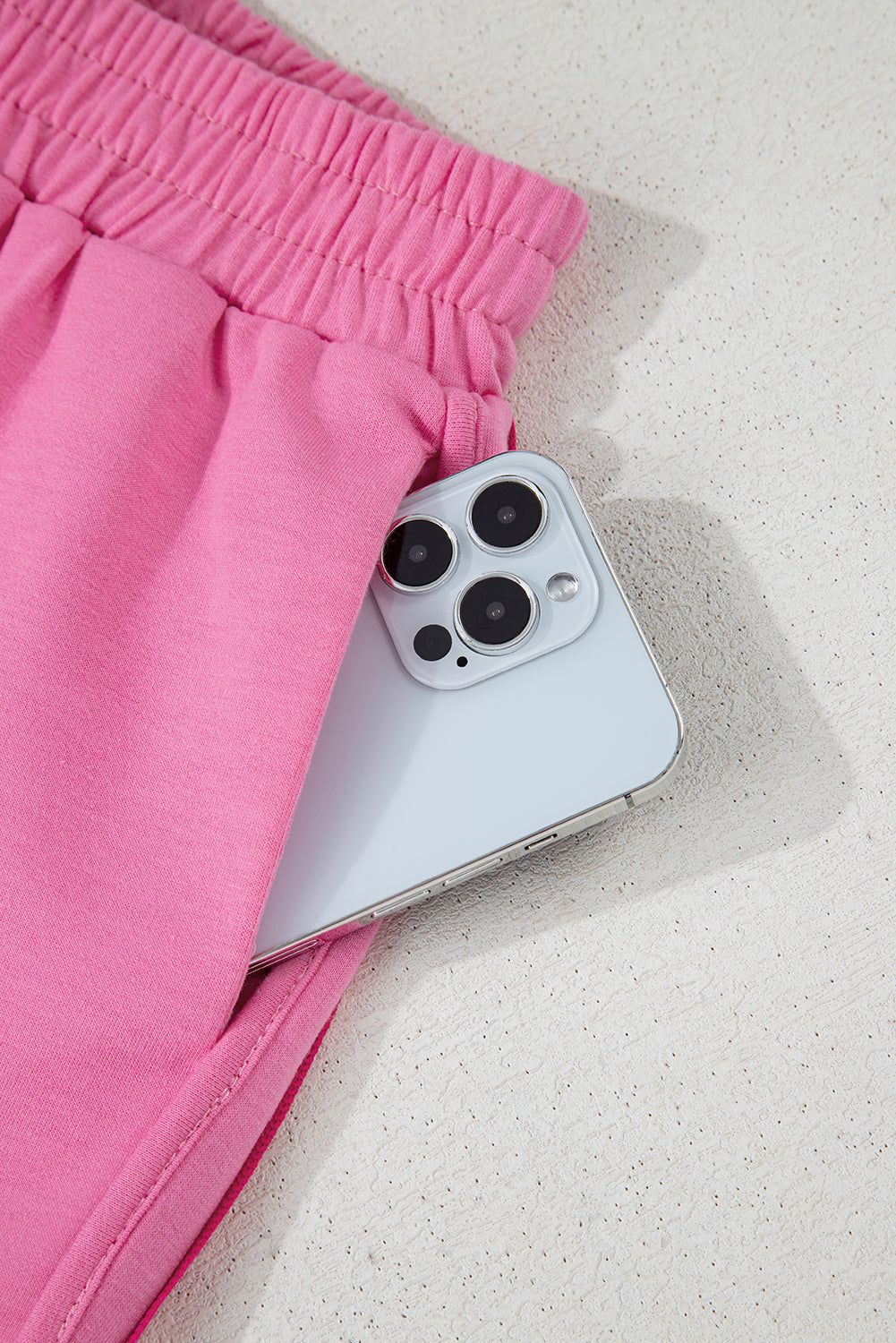 Close-up of the soft, lightweight fabric on women's pink athletic shorts with an elastic waistband.