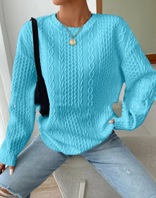 Woman wearing blue cable-knit oversized sweater with jeans, front view