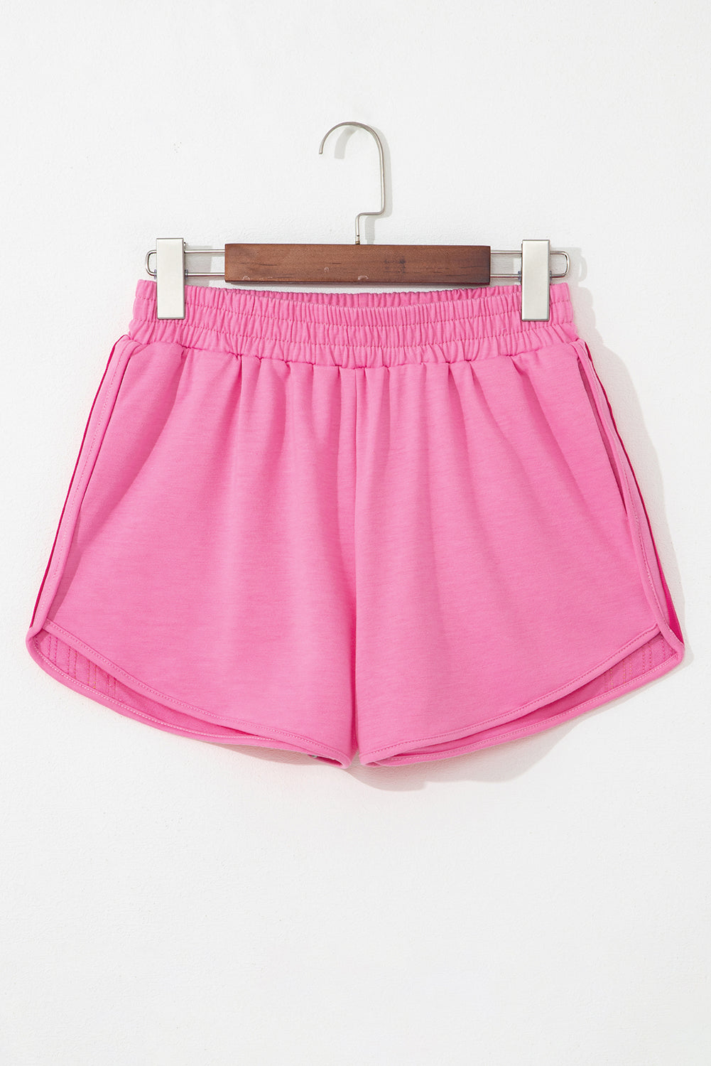 Back of women's pink high-waisted shorts with an elastic waistband and lightweight activewear fabric.