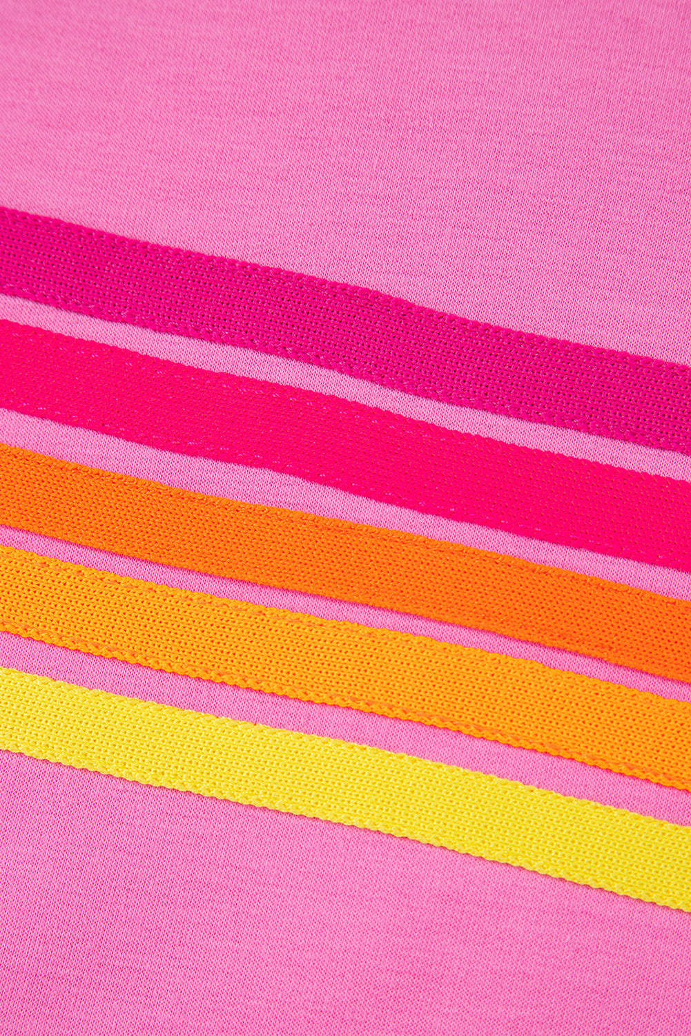 Close-up of the colorful horizontal stripe design on a soft pink women's T-shirt.